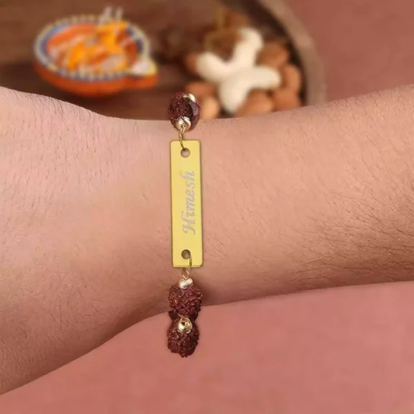 Personalized Rudraksha Rakhi worn on wrist with name Himesh engraved on golden plate