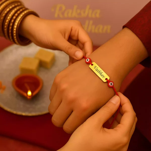 Personalized Rakhi with name Vaibhav and red evil eye beads