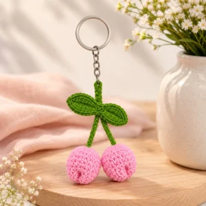 Handmade crochet tulip keychain with pink tulip flowers and green leaves on wooden display