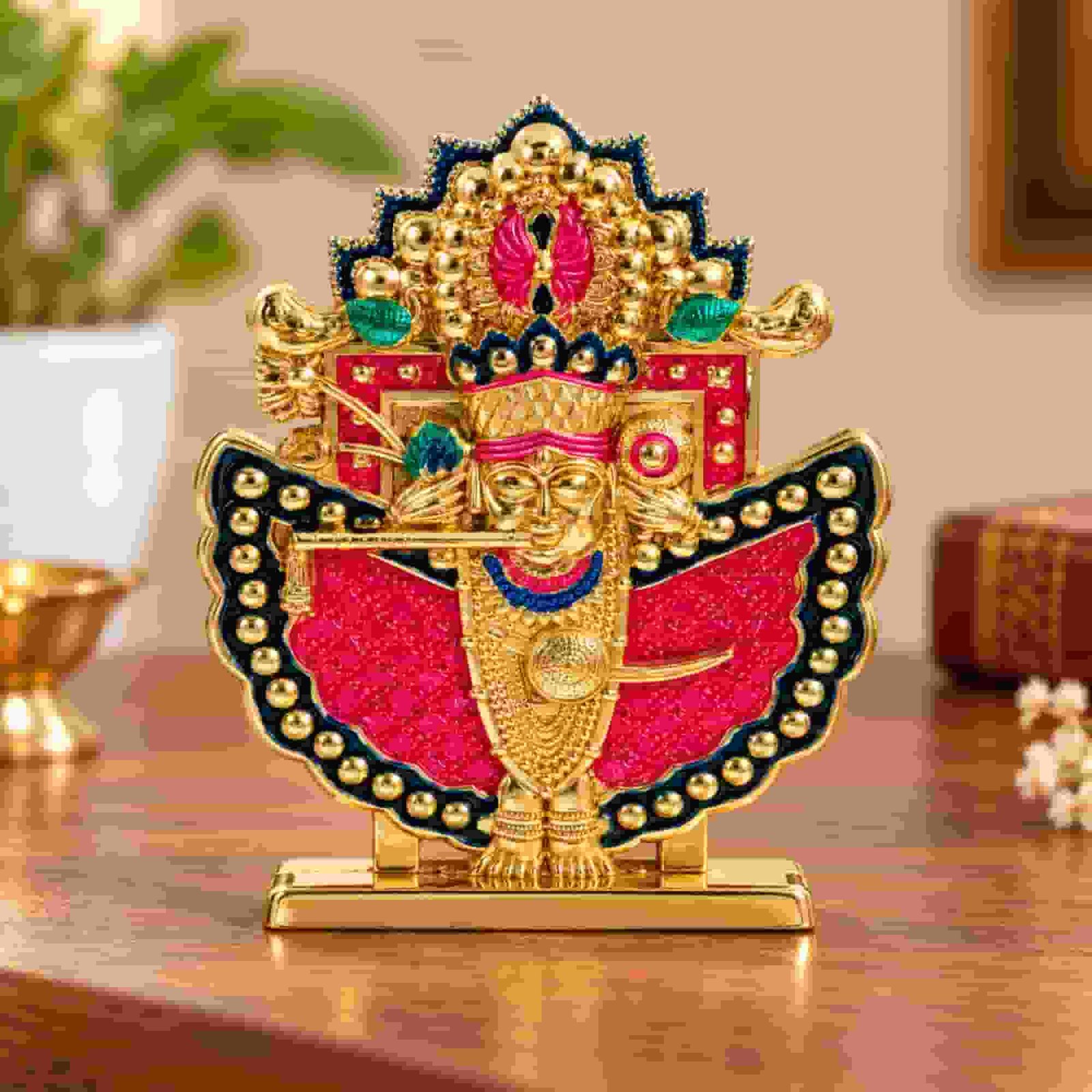 Shri Sanwaliya Seth idol with golden finish, red and navy blue detailing, ornate crown, and rectangular base displayed in a home setting.
