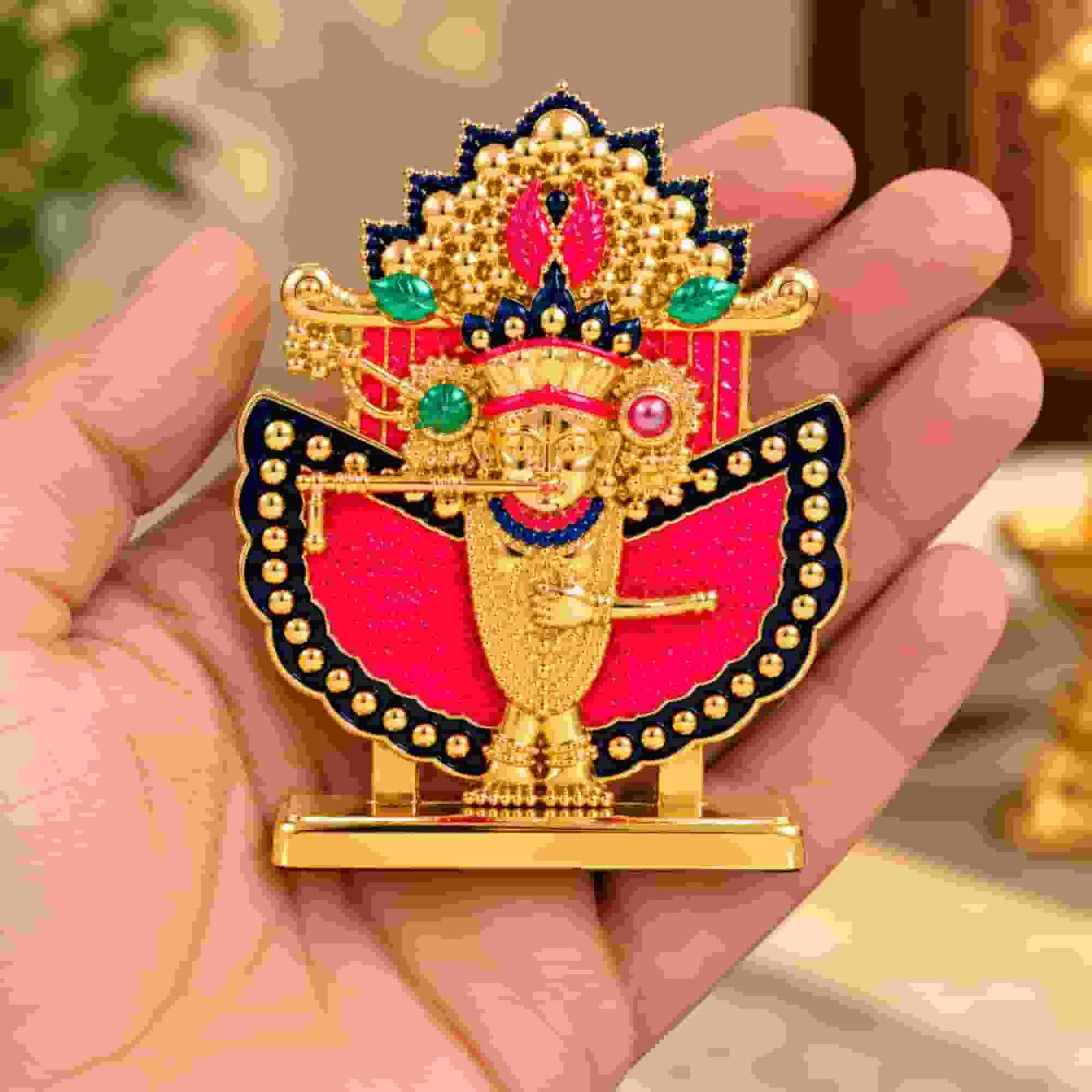 Shri Sanwaliya Seth idol in white metal with golden finish, red decorative backing, and ornate multicolored crown, shown in hand.